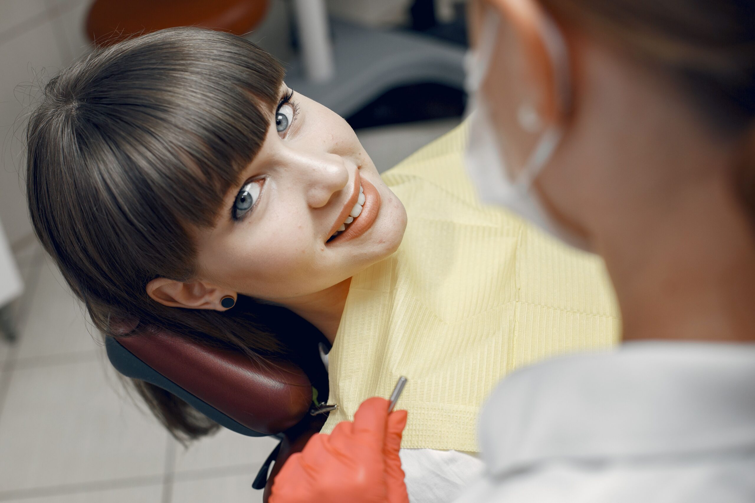 Smiling patient in a dental chair discussing cosmetic dentistry options with a dentist